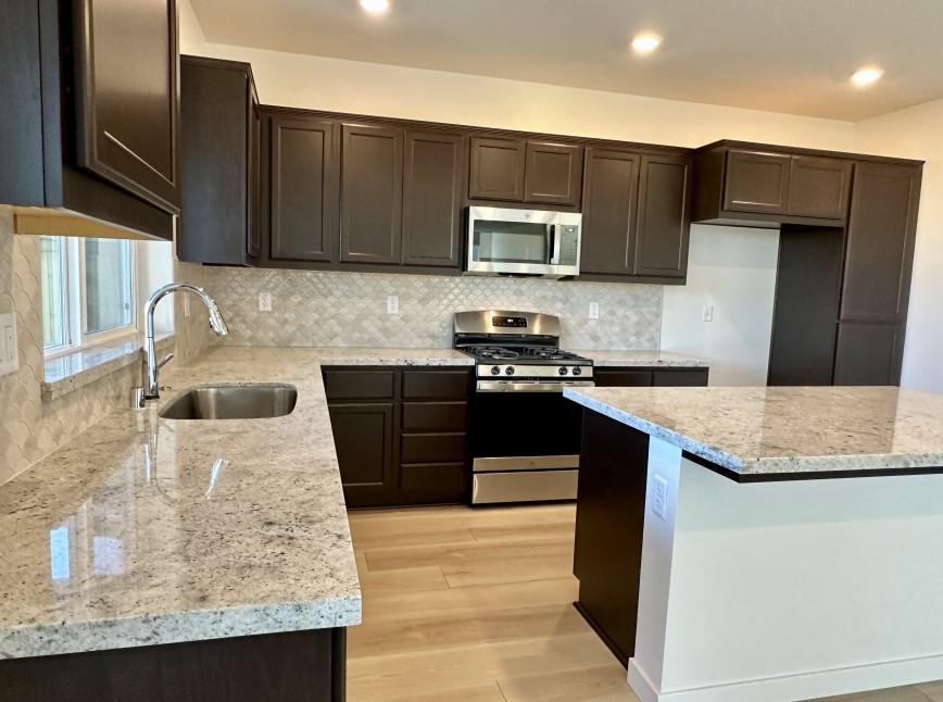 611 Willow Bend Lathrop, CA 95330 - Photo 5 of 11 a kitchen with stainless steel appliances granite countertop a sink stove and refrigerator
