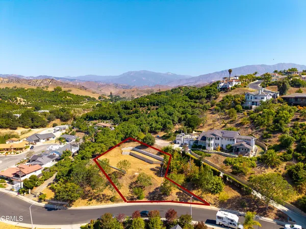 an aerial view of residential house with parking and city view