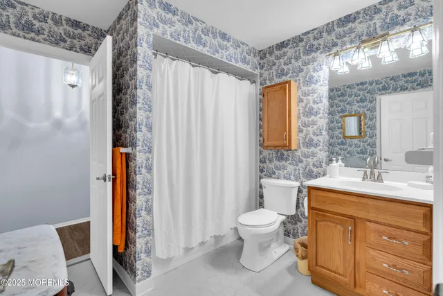 a bathroom with a toilet a sink and a large mirror