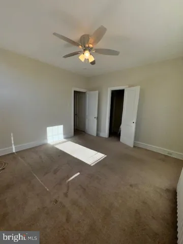 a view of a livingroom with a ceiling fan and window