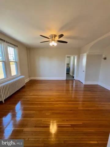 a view of a room with wooden floor and a ceiling fan