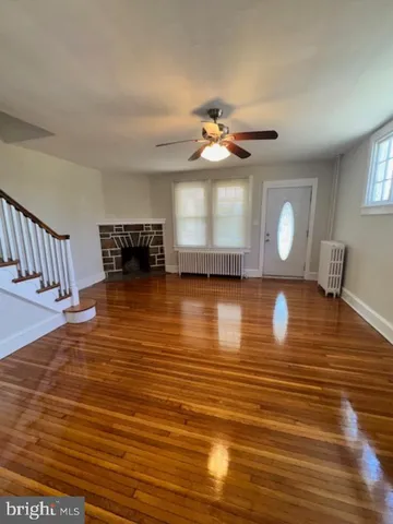 a view of a room with wooden floor and chandelier