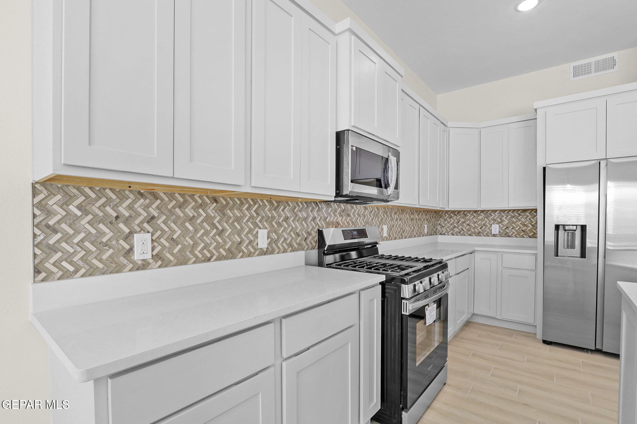 8409 Phil Place Vinton, TX 79821 - Photo 16 of 20 a kitchen with stainless steel appliances granite countertop a stove a sink and a microwave