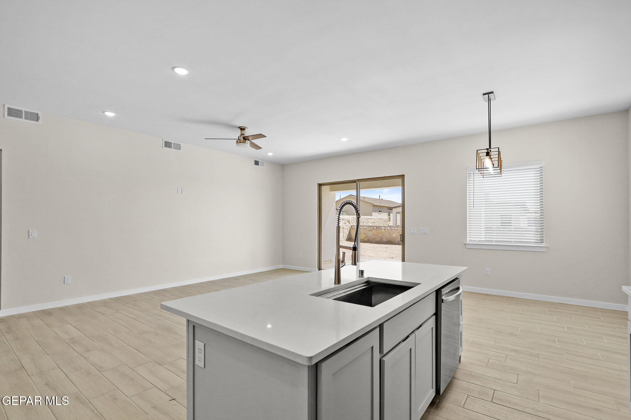8409 Phil Place Vinton, TX 79821 - Photo 4 of 20 a kitchen with a sink dishwasher and a refrigerator with wooden floor