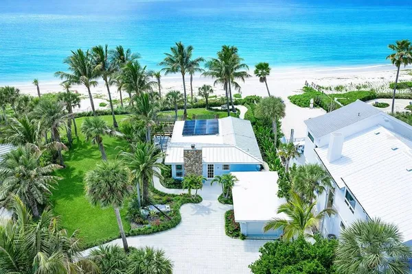 an aerial view of a house with outdoor space and trees all around