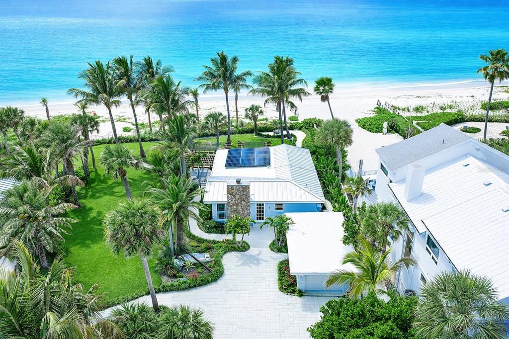 an aerial view of a house with outdoor space and trees all around