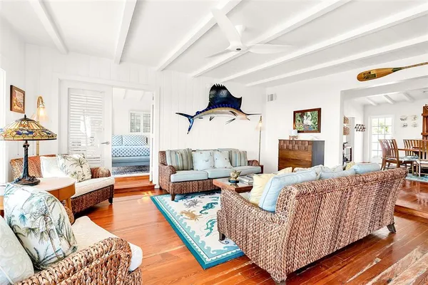 a living room with furniture wooden floor and a large window