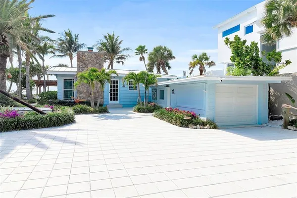a view of a house with a yard and potted plants