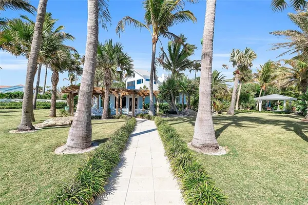 a view of a house with a patio and a yard