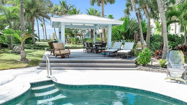 a view of a house with backyard swimming pool and sitting area