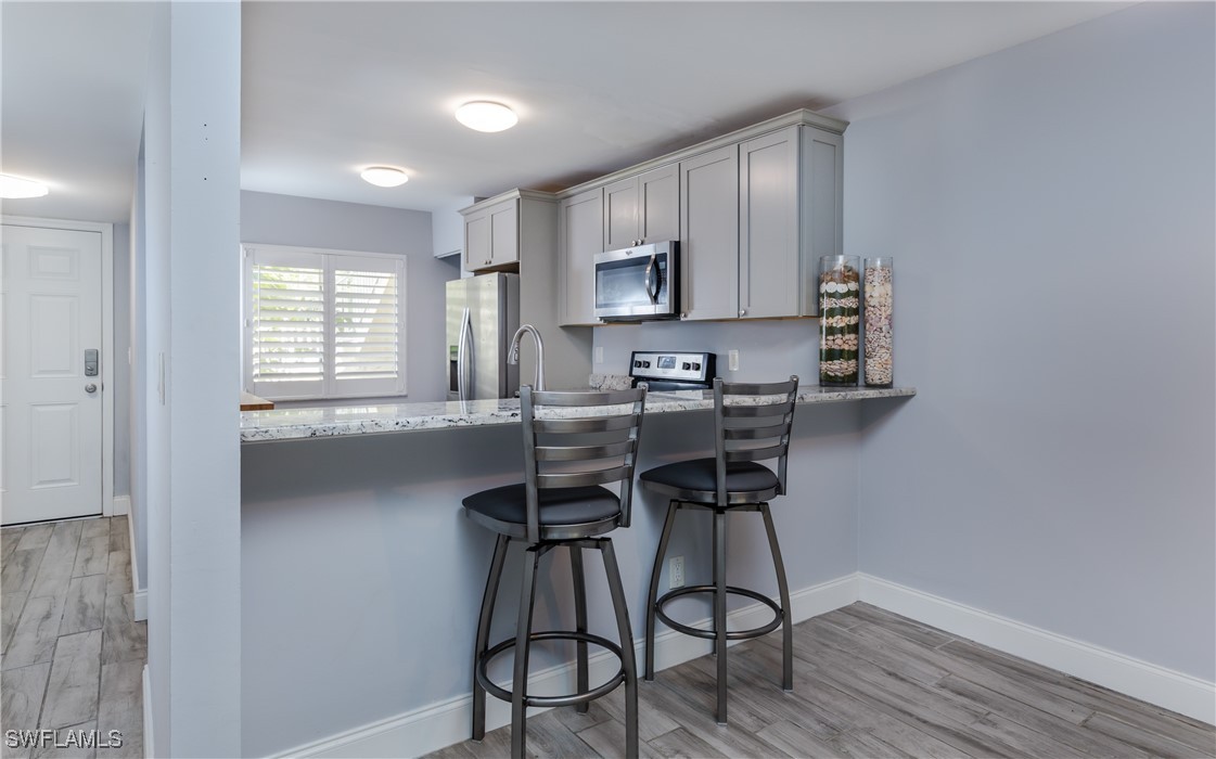 3451 County Barn Road, Unit G103 Naples, FL 34112 - Photo 11 of 25 a kitchen with stainless steel appliances a microwave a stove a sink and cabinets