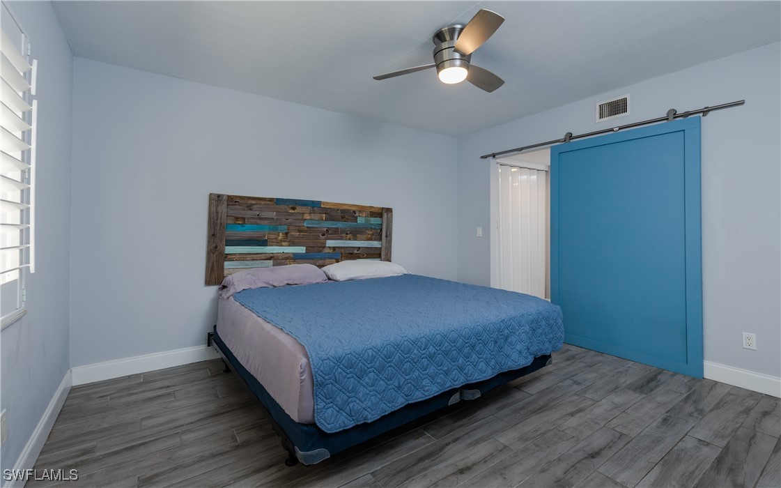 3451 County Barn Road, Unit G103 Naples, FL 34112 - Photo 15 of 25 a bedroom with a bed and wooden floor