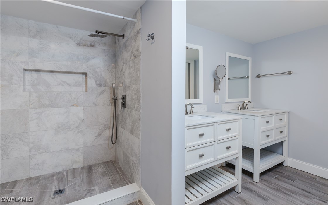 3451 County Barn Road, Unit G103 Naples, FL 34112 - Photo 16 of 25 a bathroom with a double vanity sink a mirror and a shower