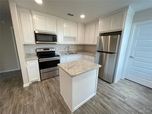 a kitchen with a refrigerator sink and microwave