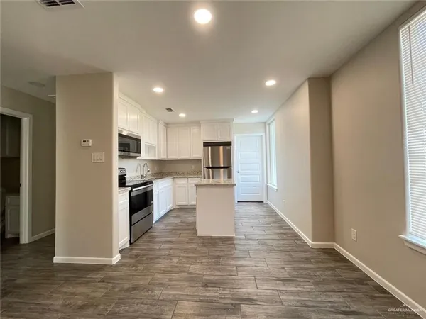 a view of kitchen with wooden floor and electronic appliances