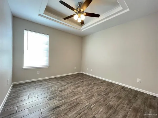 a view of an empty room and window and chandelier fan