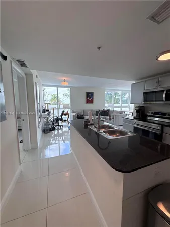a kitchen with granite countertop a refrigerator and a stove top oven