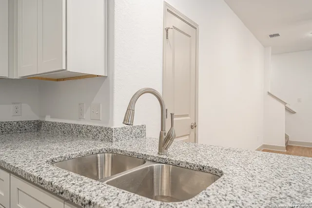 a kitchen with stainless steel appliances granite countertop a refrigerator stove and sink