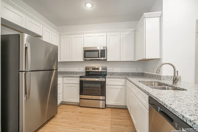 a kitchen with white cabinets and white appliances