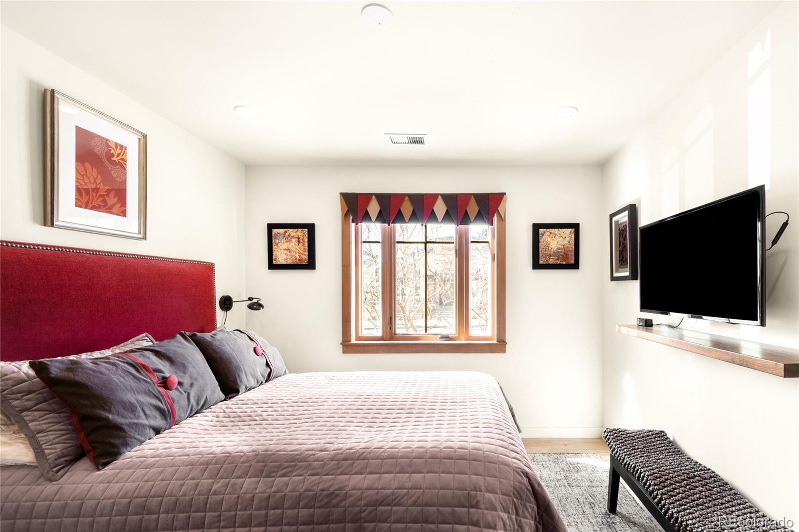 790 Clayton Street Denver, CO 80206 - Photo 13 of 32 a bedroom with a bed and a flat screen tv