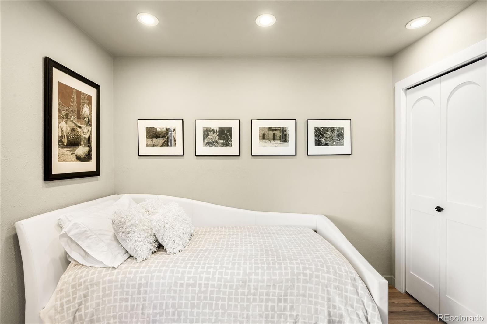 790 Clayton Street Denver, CO 80206 - Photo 16 of 32 a bedroom with a large bed and a painting on the wall