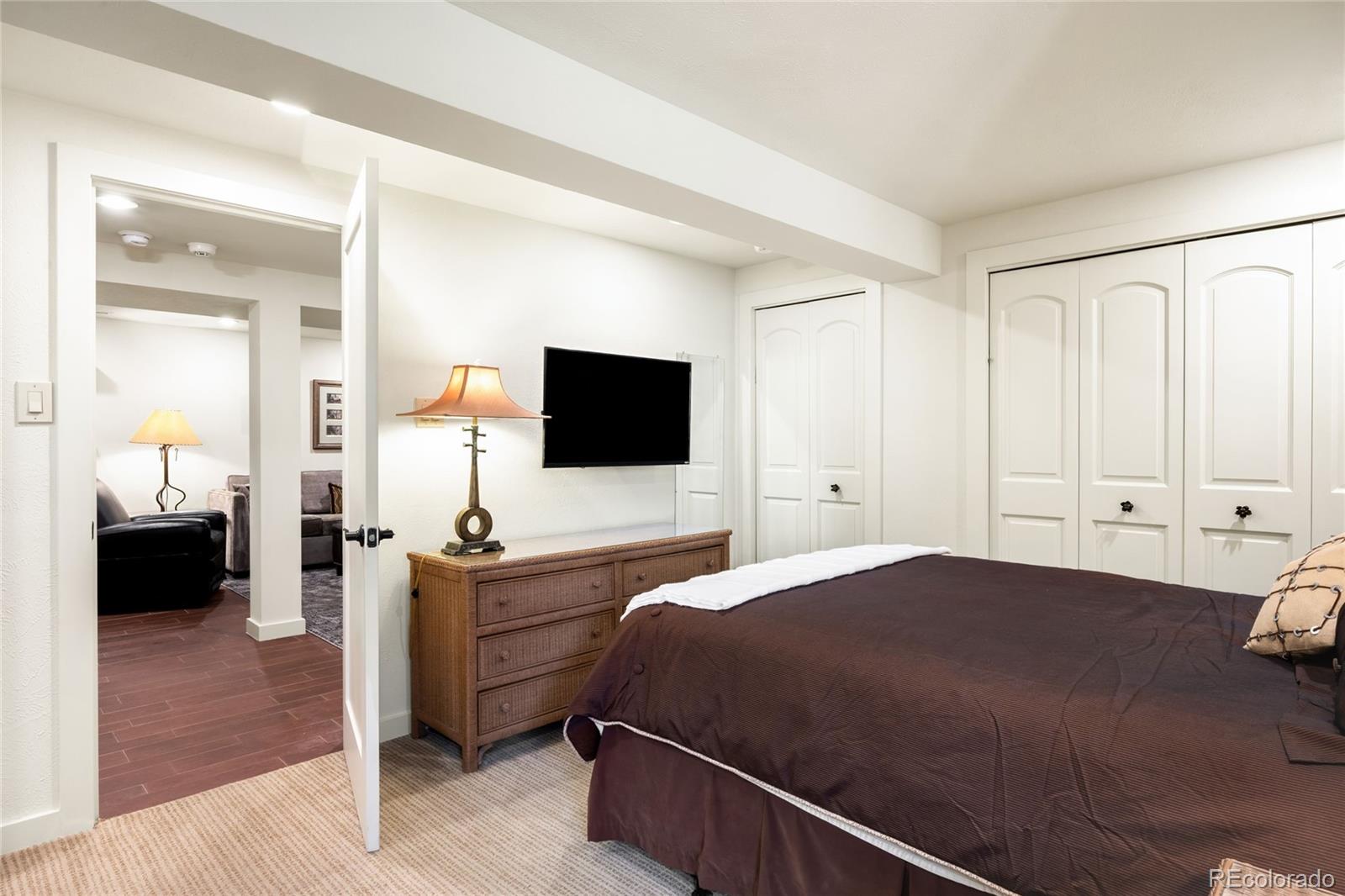 790 Clayton Street Denver, CO 80206 - Photo 23 of 32 a bedroom with a bed and a flat tv screen on wall