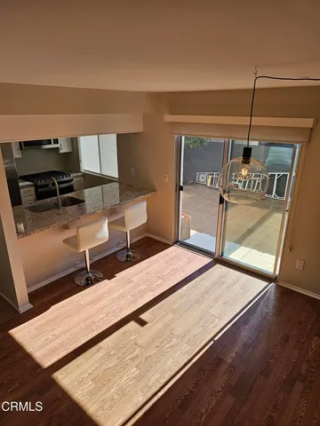 a living room with chairs and a wooden floor