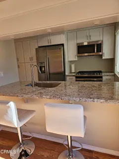 a kitchen with stainless steel appliances granite countertop a sink refrigerator and microwave