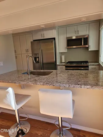 a kitchen with stainless steel appliances granite countertop a sink refrigerator and microwave