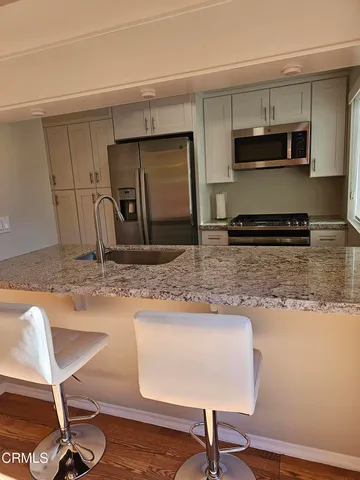 a kitchen with stainless steel appliances granite countertop a sink refrigerator and microwave