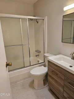 a bathroom with a granite countertop sink toilet and shower