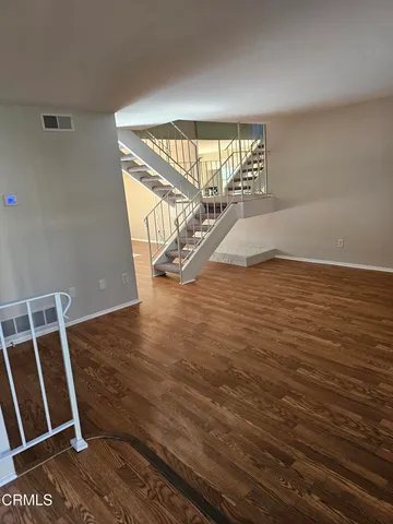 a view of a room with wooden floor and windows