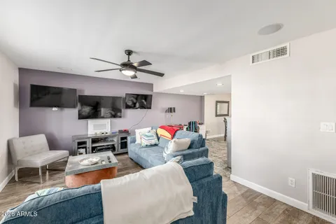 a living room with furniture kitchen view and a flat screen tv