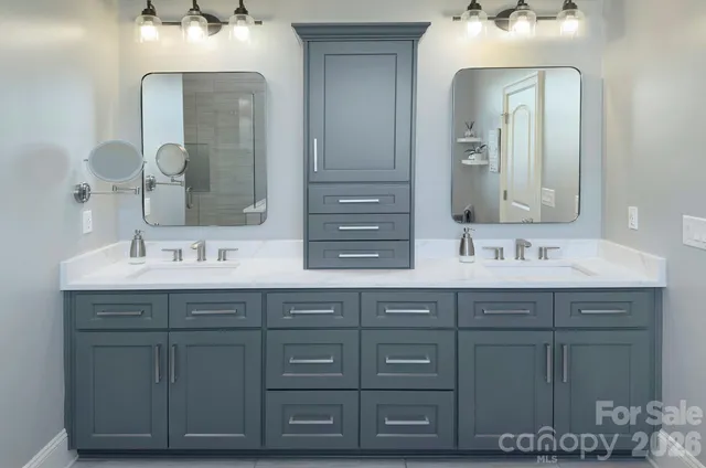 a bathroom with a double vanity sink mirror and shower