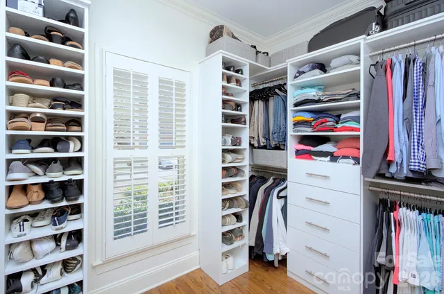 a view of walk in closet with clothes and shoes