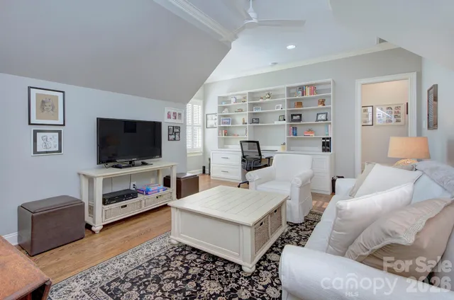 a living room with furniture a flat screen tv and a large window