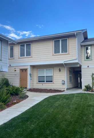a front view of a house with a garden and plants