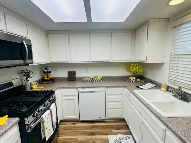a kitchen with a sink stove top oven and cabinets