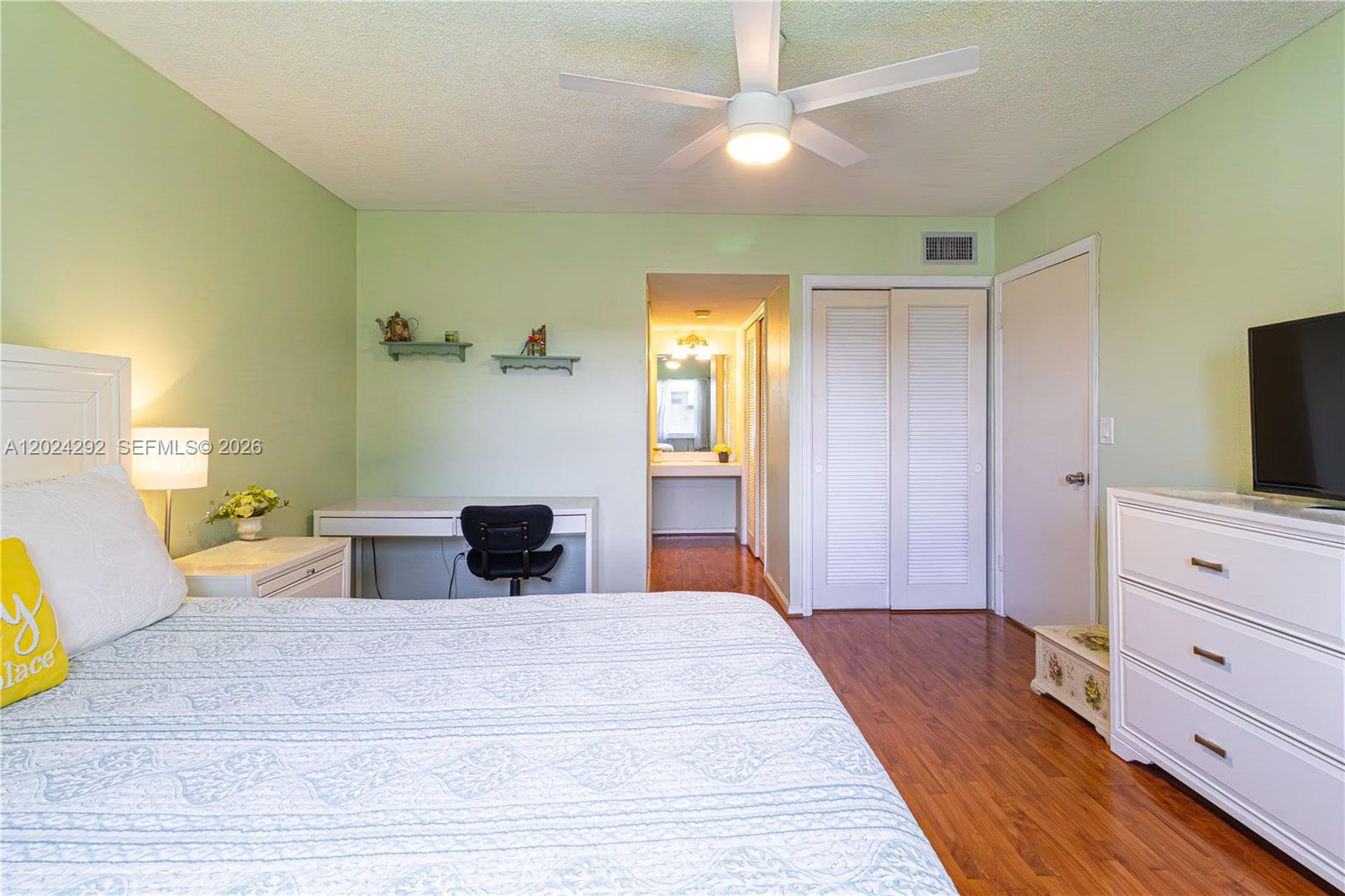 9780 Marina Boulevard, Unit 424 Boca Raton, FL 33428 - Photo 20 of 32 a bedroom with a bed and a flat tv screen on dresser