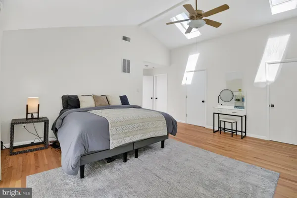 a bedroom with a bed lamps and a dresser
