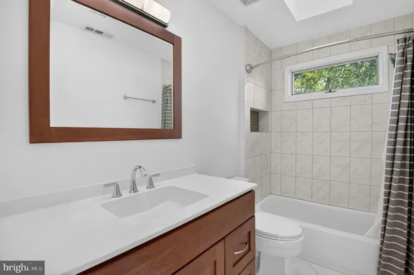 a bathroom with a sink mirror toilet and bathtub