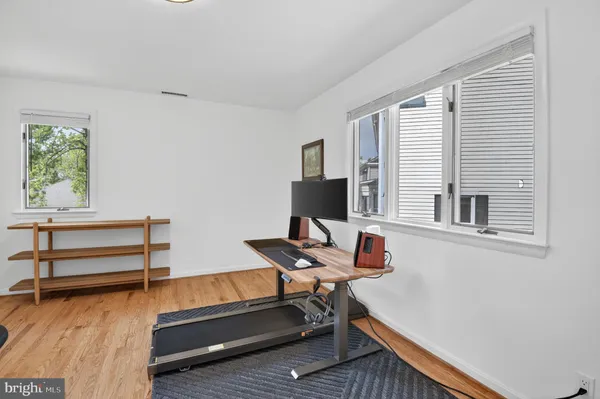 a view of a workspace with furniture and a window