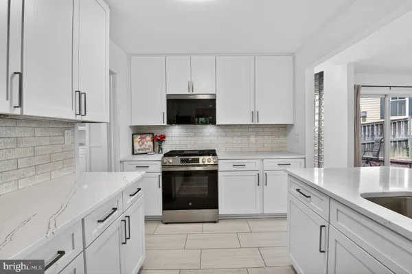 a kitchen with cabinets appliances a sink and a counter top space