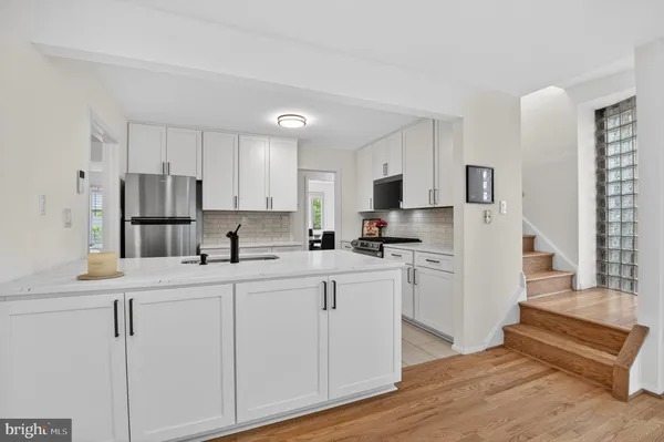 a kitchen with white cabinets and refrigerator