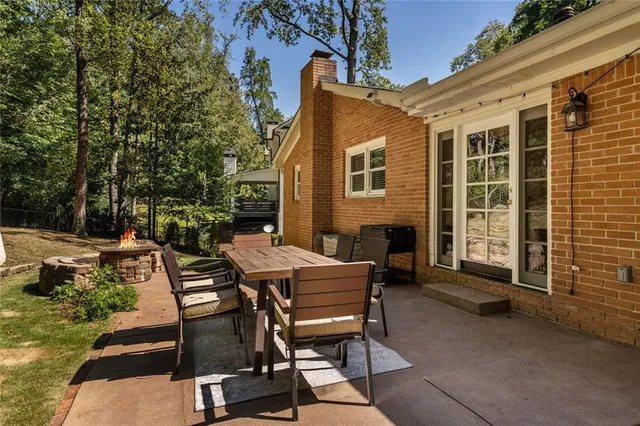 a view of a patio with table and chairs with wooden floor and fence