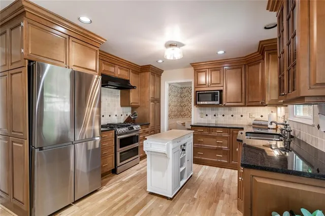 a kitchen with stainless steel appliances a refrigerator sink and microwave