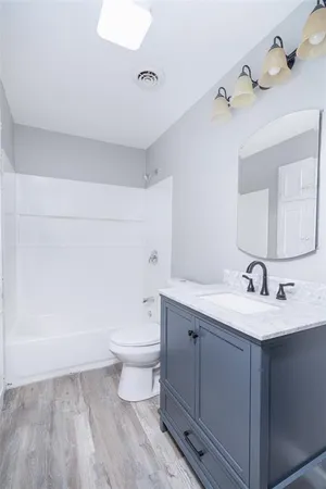 a bathroom with a sink a toilet and a mirror