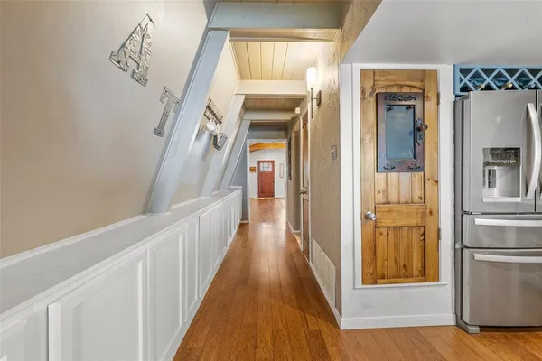 a view of a hallway with wooden floor and staircase