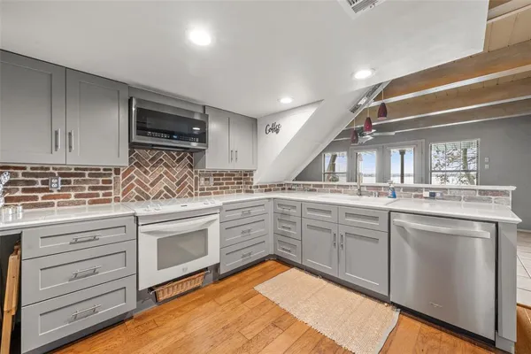 a kitchen with granite countertop stainless steel appliances sink and cabinets