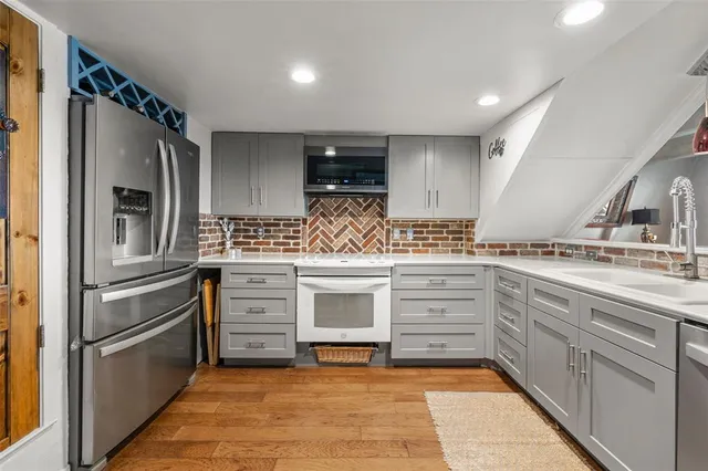 a kitchen with white cabinets and stainless steel appliances